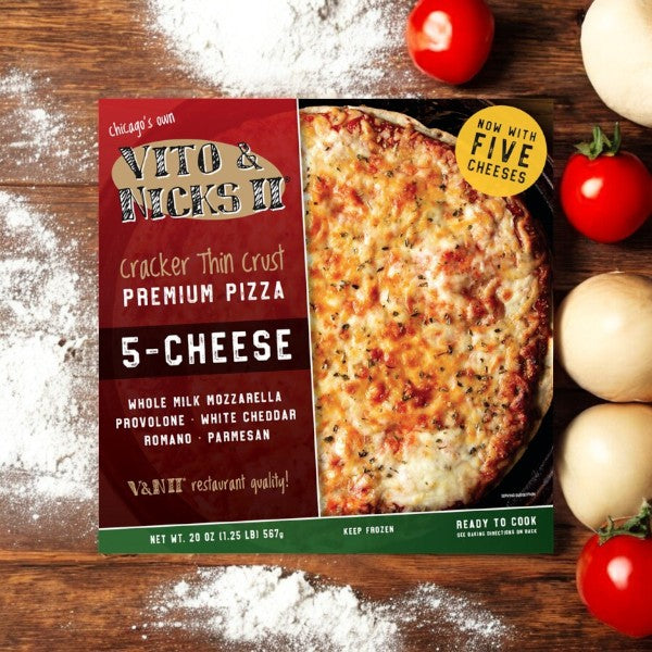 On a wooden table with flour, tomatoes, and onions sits a pizza box labeled "Vito & Nick's II Cracker Thin Crust 5-Cheese Pizza, 20 oz," featuring their signature Chicago Tavern-Style cracker thin crust.