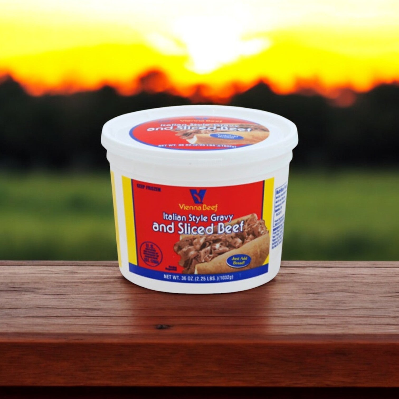 A container of Vienna Beef Italian Style Gravy and Sliced Beef, part of the Home Run Inn and Vienna Beef Chicago-Style Favorites Combo by Easy Lunches, sits on a wooden surface under a sunset glow, perfectly complementing your favorite Home Run Inn Pizza.