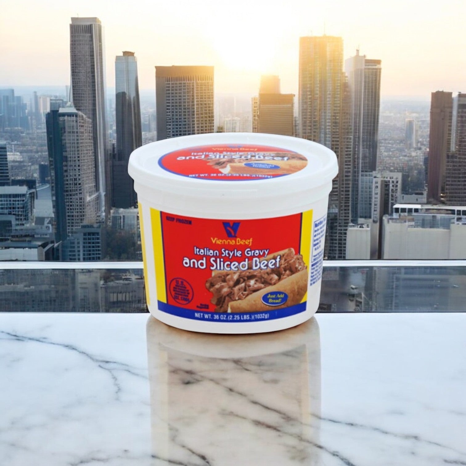 A container of Easy Lunches Vienna Beef Italian Gravy & Sliced Beef + Garrett Popcorn Tin rests on a marble surface. The setting sun casts its glow, with a city skyline providing the perfect backdrop for this savory delight.