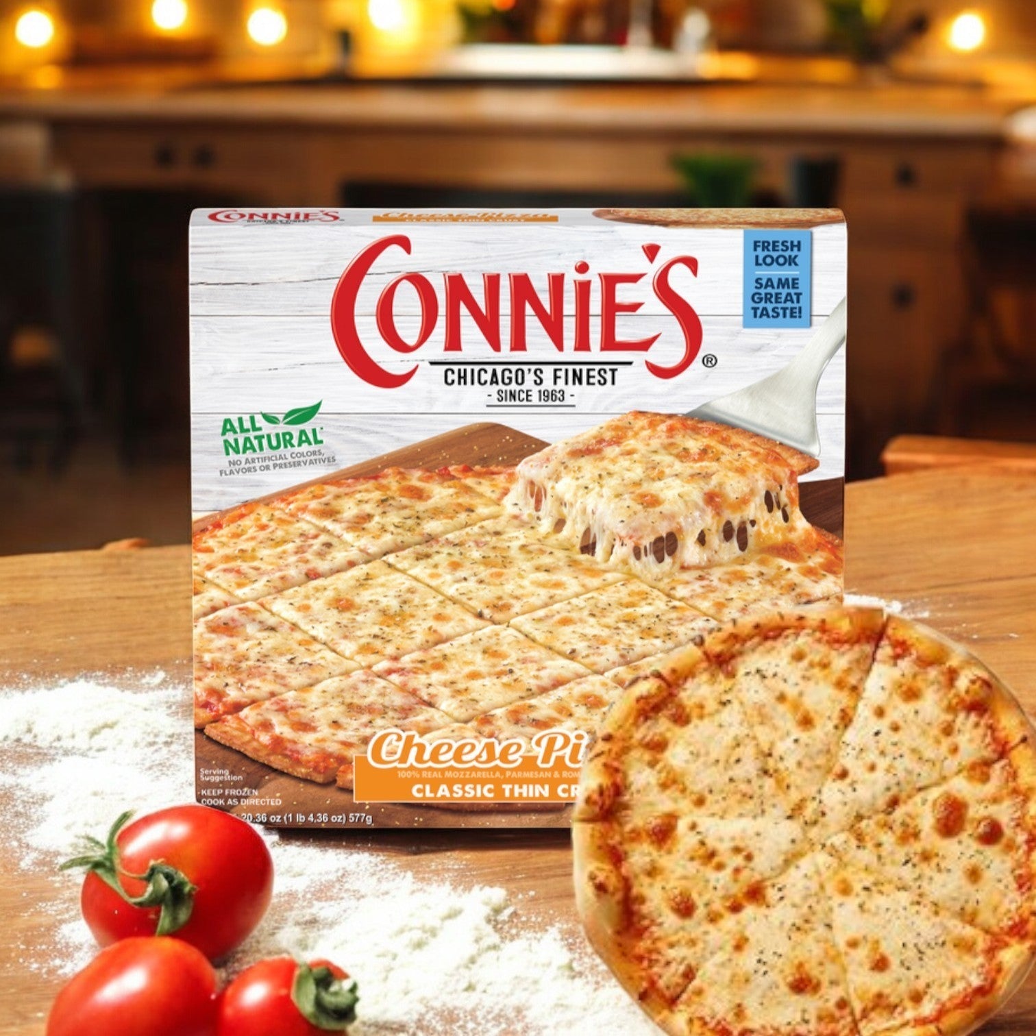 Connie's Pizza, Classic Thin Crust Cheese (20.36 oz, 1 Pack), offers a delightful baking experience with mozzarella cheese on a wooden surface alongside tomatoes and flour.
