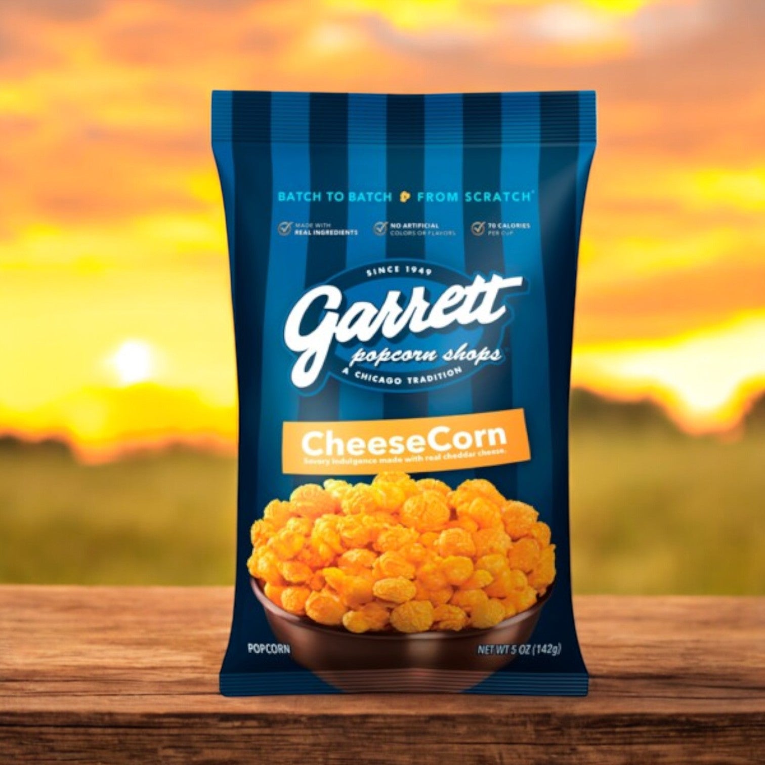 A 5 oz bag of Garrett Popcorn CheeseCorn sits on a wooden surface, its golden color vibrant against a stunning sunset, with hints of CaramelCrisp promising a delightful taste adventure.