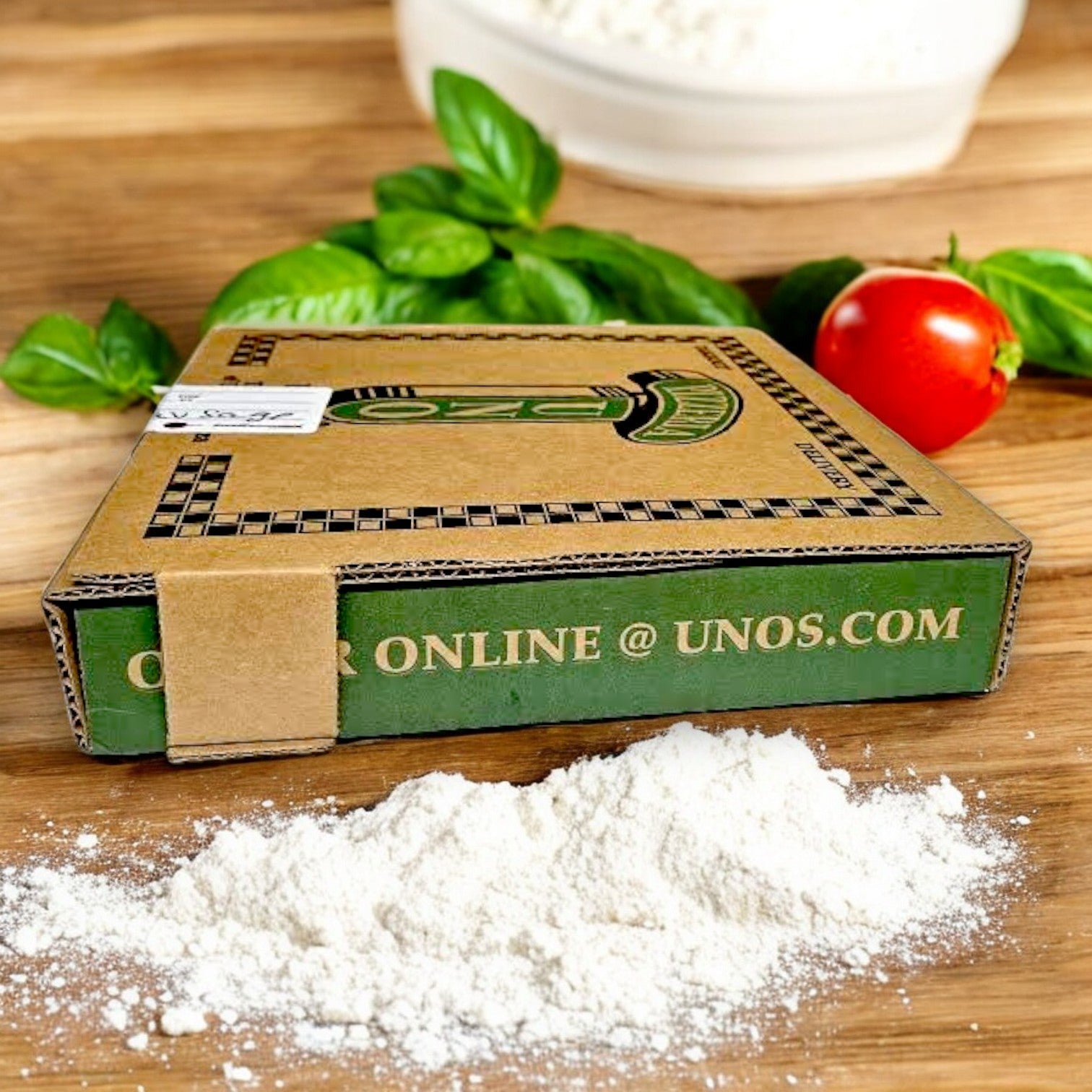 A Pizzeria Uno Deep Dish Small Sausage Pizza sits on wood next to flour, fresh basil, and a tomato, hinting at the delicious creation of this 9” frozen restaurant-made classic.